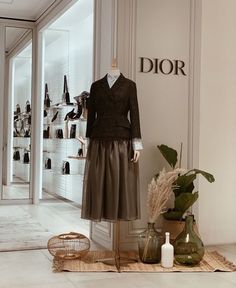 a mannequin in a shop window with shoes and vases on the floor