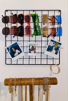 a rack with sunglasses hanging from it's sides next to a pair of glasses