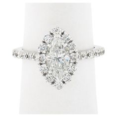 an oval cut diamond ring with halos on the band and shoulders, set in 18k white gold