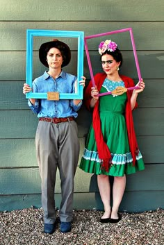 a man and woman are holding up frames in front of their faces as they stand next to each other