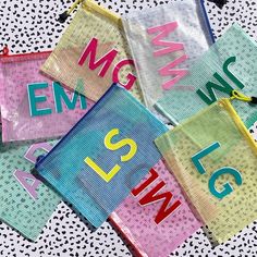 four small bags with letters on them sitting on a polka dot tablecloth covered surface