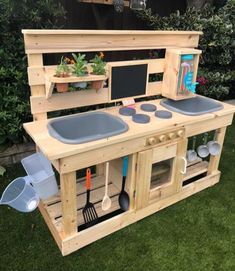 an outdoor play kitchen made out of pallets and wooden planks with pots and pans on top