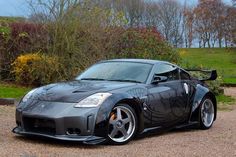 a black sports car parked in front of some bushes