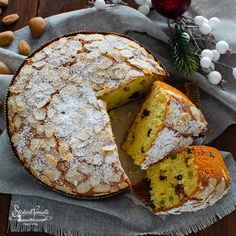 a cake that has been cut into pieces and is sitting on a table next to some nuts