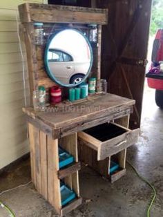 a wooden vanity with a mirror on it and some paint cans in the bottom drawer