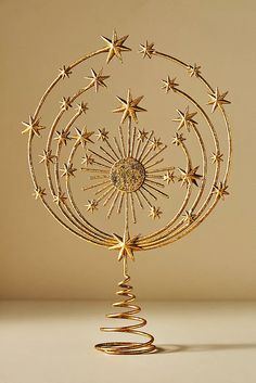 a gold christmas tree decoration with stars on it's top and spirals in the middle