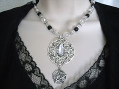 "This lovely necklace has a pewter silver pendant featuring all the signs of the zodiac with a clear faceted glass setting. It has clear Czech glass beads, black pearl beads, seed beads, pewter silver accent beads and a pewter silver pentacle. 20\" long. Toggle clasp." Gothic Silver Round Necklace, Silver Gothic Round Necklace, Silver Gothic Jewelry For Costume, Gothic Pendant Jewelry For Larp, Gothic Pewter Pendant Necklace, Gothic Nickel-free Jewelry For Larp, Goddess Witchcraft, Pentacle Necklace, Wicca Jewelry