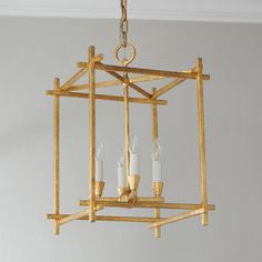 a golden chandelier with candles hanging from it's center piece in a room