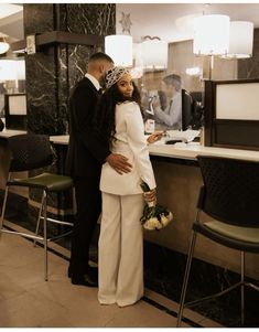 a man and woman standing next to each other in front of a counter