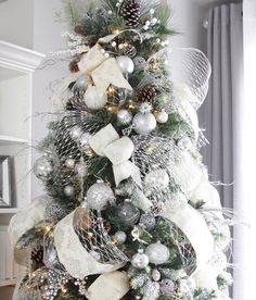 a christmas tree decorated with silver and white ornaments is shown in this instagram photo