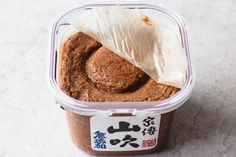 a plastic container filled with food on top of a white countertop next to chinese writing