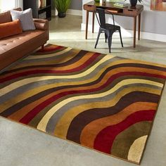 a living room filled with furniture and a rug on top of a carpeted floor