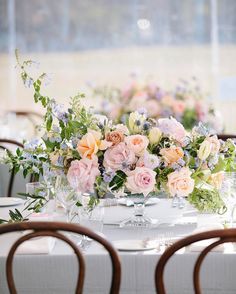 the table is set with flowers and wine glasses on it for an elegant wedding reception