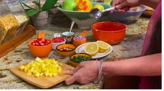 the woman is preparing her food on the kitchen counter with many bowls and spoons