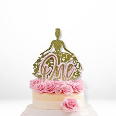 there is a cake that has pink flowers on the bottom and gold lettering on top