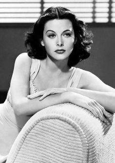 a black and white photo of a woman sitting on a couch with her arms crossed