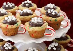 hot chocolate cookie cups on a plate with candy canes and marshmallows