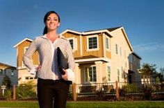 a woman standing in front of a house with the words call now on her shirt