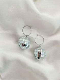 These Disco Ball Hoops are trendy, unique and hypoallergenic! Dimensions: 1x 2 in.  All items are made with love in Sacramento, CA. Earrings come on our silver hoops that are simple, lightweight and super comfy for all day wear. -- CARE -- We recommend removing jewelry before showering, swimming or sleeping to extend their shiny, wearable life. Scratches may occur during wear so be sure to keep them in a safe, dry place when not sporting them. Disco Ball Stud Earrings, Fun Silver Metal Jewelry, Trendy Hypoallergenic Jewelry For Parties, Fun Nickel-free Metal Jewelry, Trendy Silver Hoop Earrings For Party, Trendy Nickel-free Hoop Earrings For Party, Trendy Nickel-free Jewelry For Party, Trendy Nickel Free Jewelry For Parties, Hypoallergenic Adjustable Earrings For Party