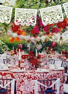 the table is set with red and white linens, paper doily hanging from the ceiling