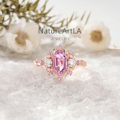 a pink diamond ring sitting on top of snow