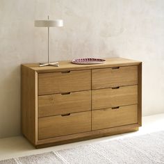 a wooden dresser with drawers and a lamp on top