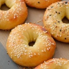 bagels with sesame seeds are sitting on a baking sheet