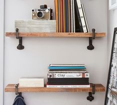 two wooden shelves with books, camera and other items on them next to each other