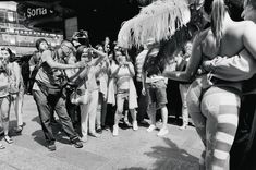 a group of people standing around each other in front of a building and taking pictures