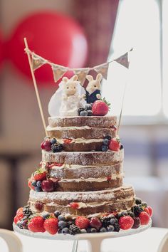 a wedding cake is decorated with berries and bunting