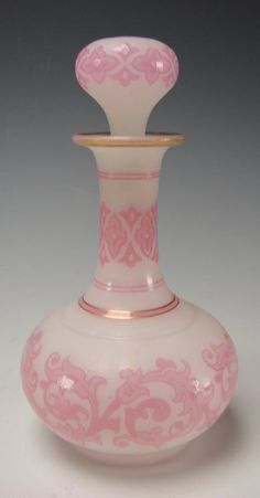 a pink and white vase sitting on top of a table