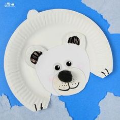 a paper plate with a polar bear cut out of it's face on a blue background