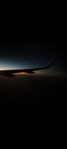 an airplane wing in the sky at night