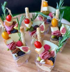 fruit and cheese appetizers are arranged in small cups