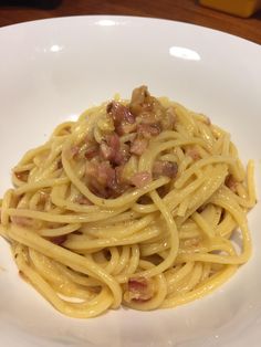 a white plate topped with pasta covered in sauce