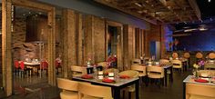 an empty restaurant with tables and chairs set up for formal dinner or special event in front of a brick wall