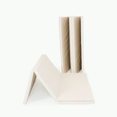 three pieces of white paper stacked on top of each other in front of a white background