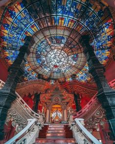 the interior of a building with stained glass windows and stairs leading up to an entrance