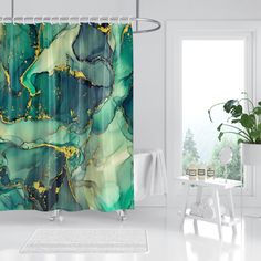 a green and gold shower curtain in a white room with a potted plant next to it