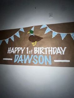 a happy 1st birthday sign with a duck on it's head and bunting