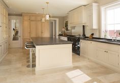 a large kitchen with white cabinets and black counter tops, along with an island in the middle