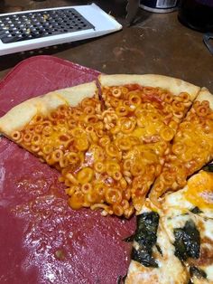 two pizzas with different toppings on them sitting on a table next to a calculator