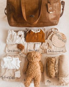 a brown teddy bear sitting next to a purse and other items on a white surface