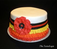 a white cake with orange, yellow and black ruffles