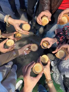 a group of people sitting around each other holding cups in their hands and drinking coffee