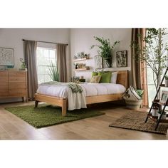 a bed room with a neatly made bed and green rugs on the wooden floor