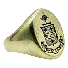 This is part of Chairish’s Fine Jewelry assortment.  This 14k gold signet ring features a family crest of a shield topped with a radiating cross. The shield is divided into three sections, with vertical lines across the top and bottom sections, and a row of fleur-de-lis across the center. Above the shield is a cross like symbol that contains a tiny image that appears to be a book. Below the shield is a banner with the Latin phrase  “Spiritus Gladius” which translates to “Sword of the Spirit.” A 14k Gold Signet Ring, Like Symbol, Latin Phrases, Vertical Lines, Gold Signet Ring, The Shield, Unisex Ring, Small Rings, Family Crest