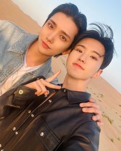 two young men standing next to each other in the desert