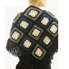 a woman is wearing a crocheted shawl with snowflakes on it