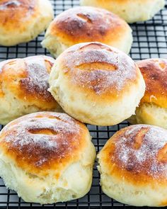 freshly baked rolls on a cooling rack with powdered sugar sprinkled on top